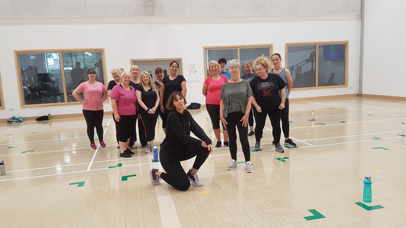 Dance learners posing with their instructor