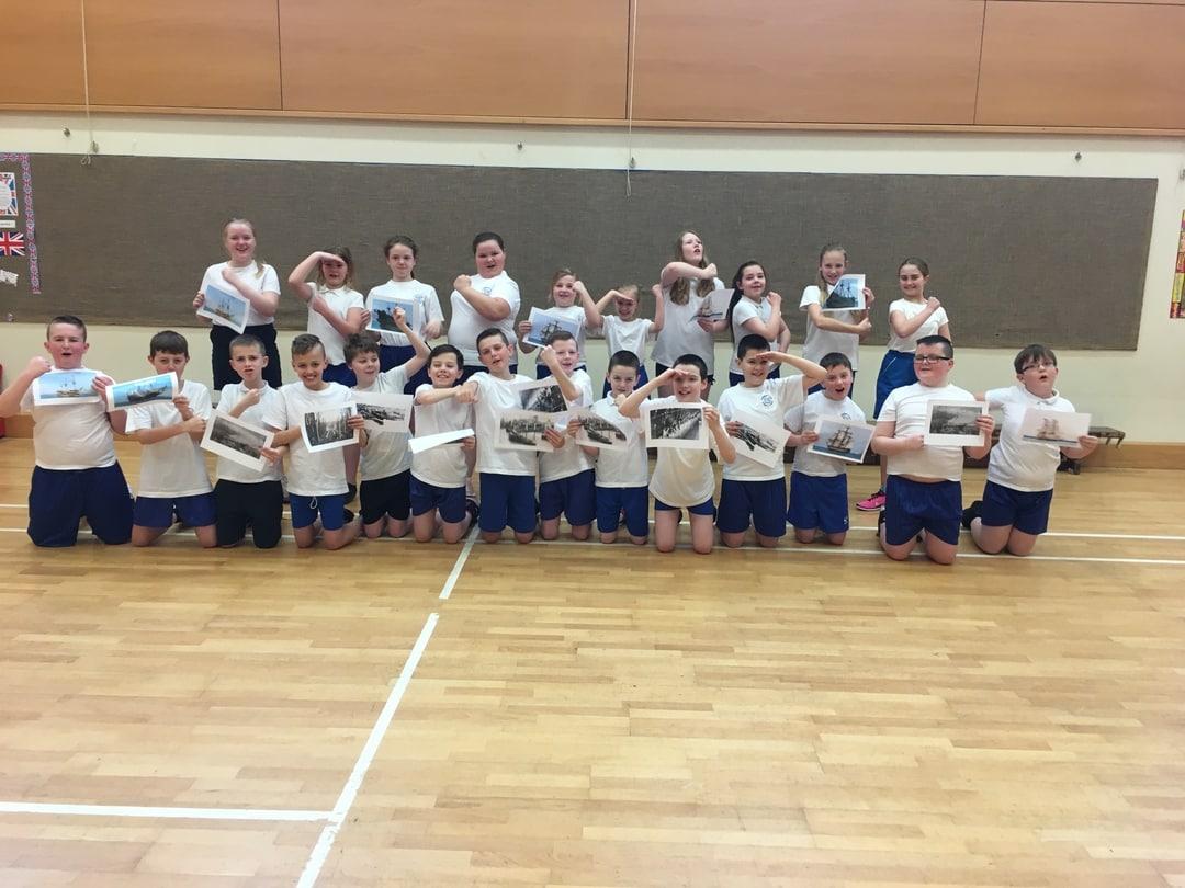 A group of kids facing the camera taking a group photo