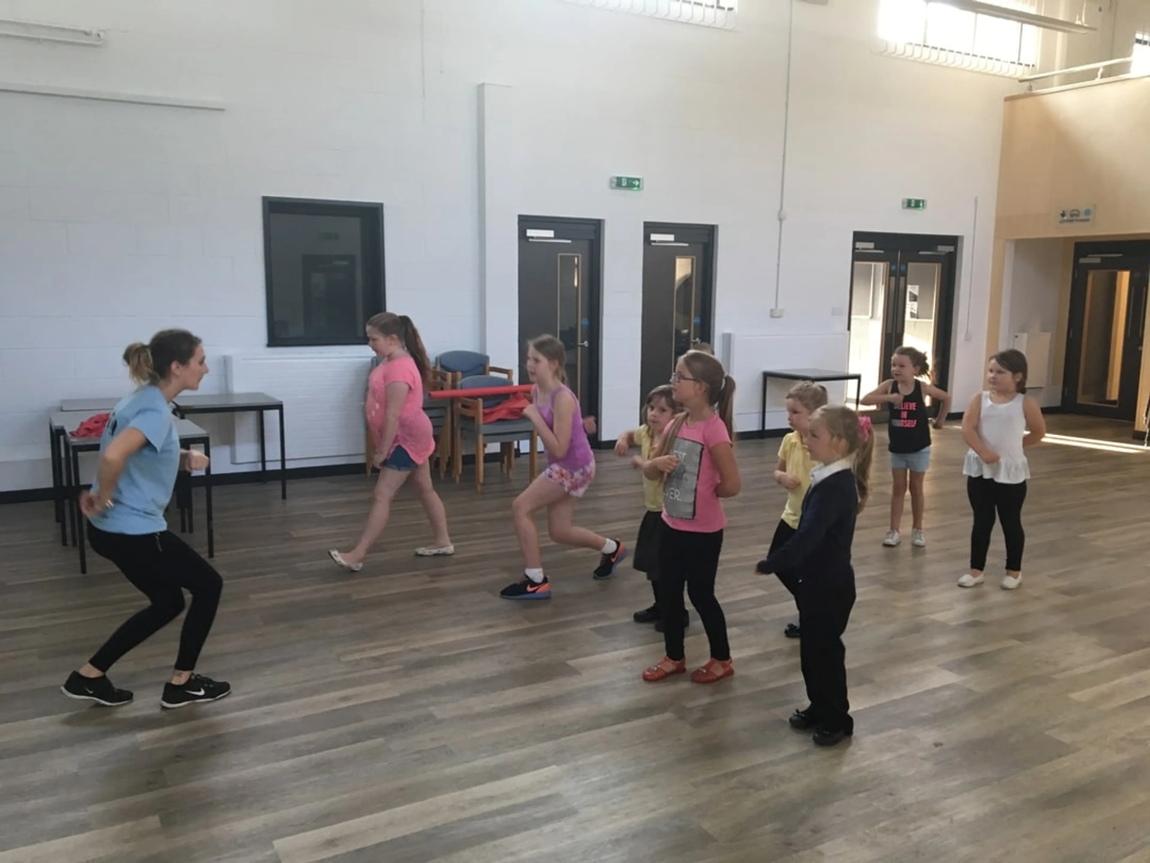 A group of kids taking a dance lesson