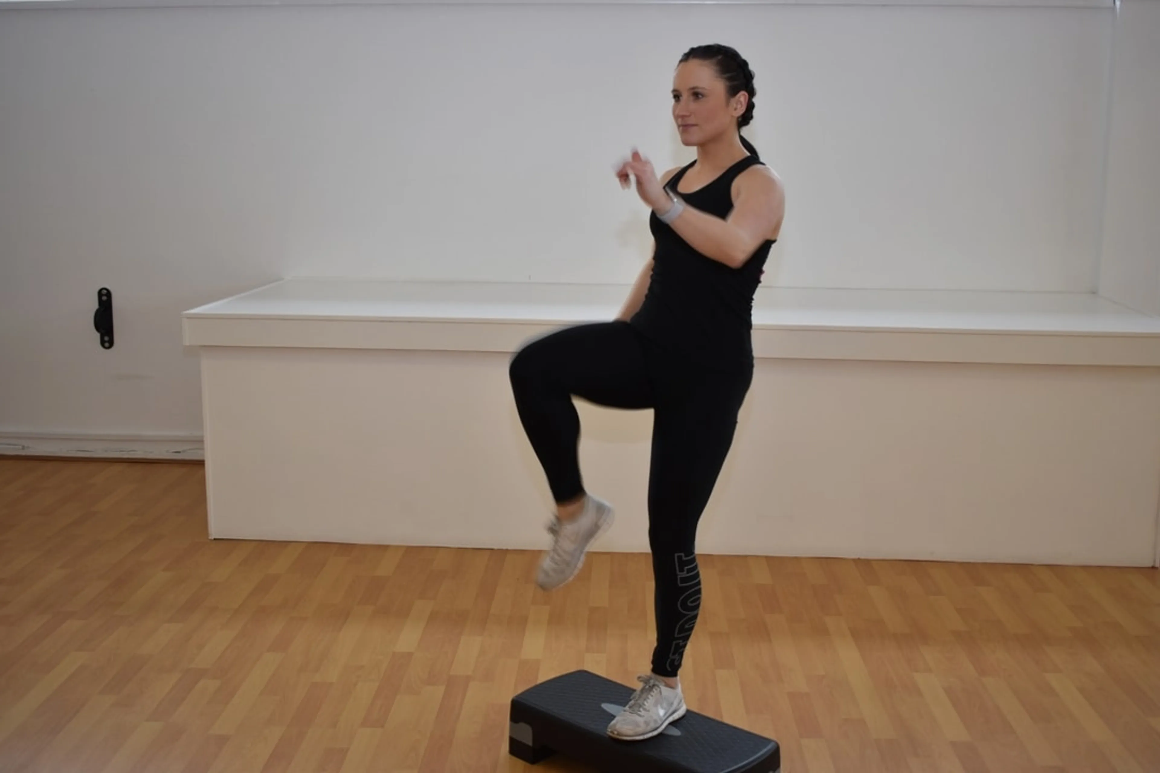 Woman using a step up platform in a dance studio